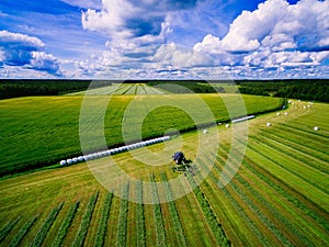 Aerial view of Tractor mowing green field in Finland