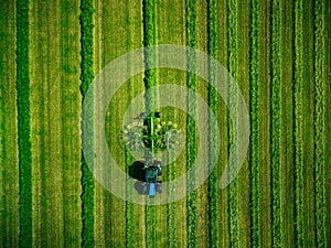 Aerial view of Tractor mowing green field in Finland