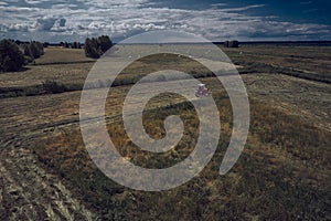 Aerial view of Tractor mowing green field in summer Finland