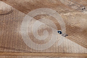 An aerial view of a tractor plowing in a field.