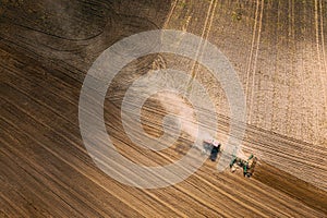 Aerial View. Tractor Plowing Field. Beginning Of Agricultural Spring Season. Cultivator Pulled By A Tractor In