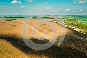 Aerial View. Tractor Plowing Field In Spring Season. Beginning Of Agricultural Spring Season. Cultivator Pulled By A