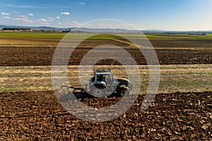 Aerial view of the tractor plows in the field