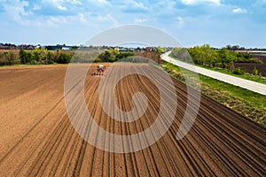 Aerial view of tractor sowing and planting corn in field