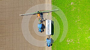 Aerial view on tractor with sprayer came for reload, herbicide and pesticide