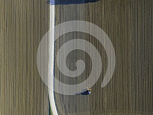 Aerial view of a tractor working in an agricultural field at sunset near Aquileia, Udine, Friuli Venezia Giulia, Italy