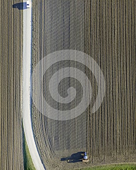 Aerial view of a tractor working in an agricultural field at sunset near Aquileia, Udine, Friuli Venezia Giulia, Italy