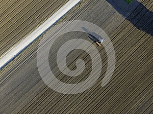 Aerial view of a tractor working in an agricultural field at sunset near Aquileia, Udine, Friuli Venezia Giulia, Italy