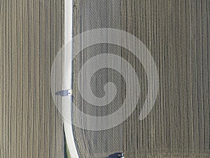 Aerial view of a tractor working in an agricultural field at sunset near Aquileia, Udine, Friuli Venezia Giulia, Italy