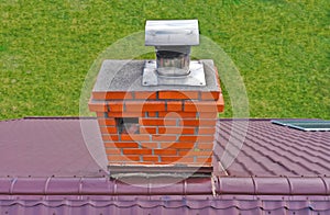 Aerial view on traditional brick chimney in red color with ventilation hole and steel pipe from furnace