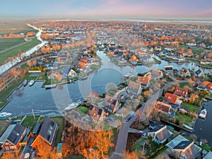 Aerial view on the traditional village Koudum in Friesland the Netherlands at sunset in winter