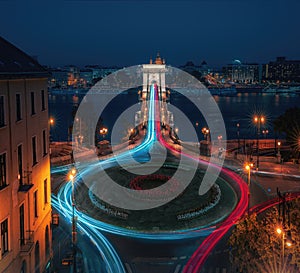 Aerial view of traffic at Clark Adam Square roundabout with Szechenyi Chain Bridge and Danube river at night - Budapest, Hungary