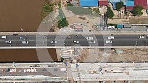Aerial view of the traffic lane and construction lane of a bridge under construction along a muddy river in Asia