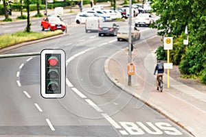 view of Traffic light above busy road in the city with cyclist, cars and public trasport lane. Road safety concept photo