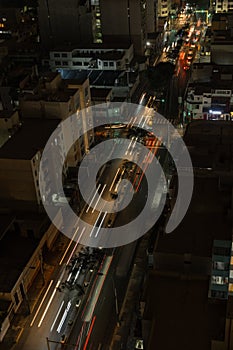 Aerial view Traffic speeds through an intersection at night on a main road. long exposure