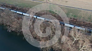 Aerial View of Train Cars in Motion Next To River and Landscape - Trucking Shot