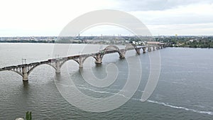 Aerial view of a train crossing a beautiful bridge. Freight train moves along the railway bridge. Aerial view of the old