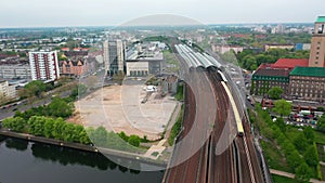Aerial view of train station. S bahn train driving on multitrack railway line leading on bridge across Havel river