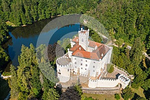 Aerial view of Trakoscan castle surrounded by the lake and forested hills