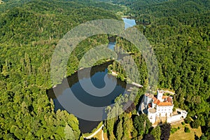 Aerial view of Trakoscan castle surrounded by the lake and forested hills