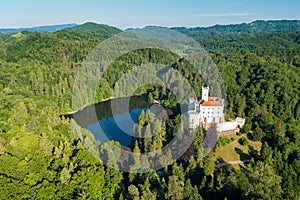 Aerial view of Trakoscan castle surrounded by the lake and forested hills