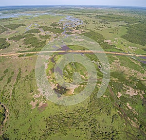 Aerial view of Transpantaneira dirt road crossing in typical Pantanal Wetlands landscape with lagoons, rivers, meadows and forest