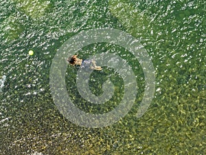 Aerial view of the Trebbia river in Val Trebbia. Boy playing ball. Italy