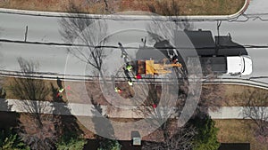 Aerial view of Tree cutting services worker loading cut tree branches into the wood chipper machine for shredding