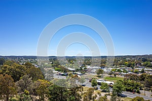 Aerial view of trees, roads, and suburban houses in Ballarat against the cloudless blue sky. photo