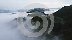 Aerial view of the trees in the valley with fog in the morning. Landscape of misty valley and mountain clouds in thailand. The