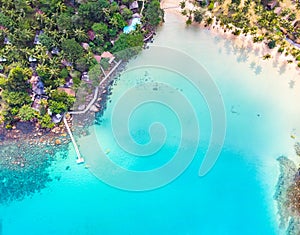 Aerial view of tropical beach at island hotel resort with blue sea water and coconut palm trees, beautiful summer vacation