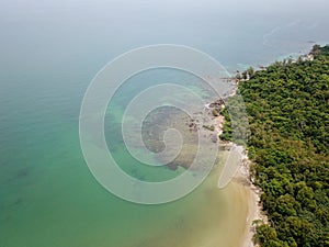 Aerial view of tropical island jungle with palms and emerald clear water