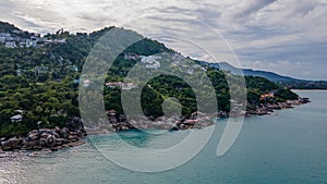 Aerial view of the tropical island landscape with beach villas and trees on hills near ocean in Thailand.Koh Samui.Asia. Drone.