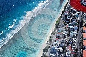 Aerial view of tropical Maldive City buildings and beach from se