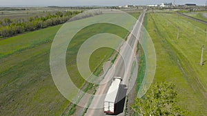 Aerial view Truck. A large delivery truck moves in a beautiful countryside. Aerial view. White truck on the highway -