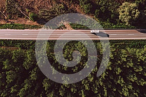 Aerial view of truck on road through forest landscape