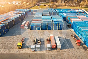 Aerial view of trucks and containers at sunset. Top view