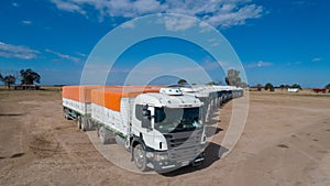 Aerial view of trucks prepared to load corn grains after harvest in the field.