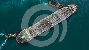 Aerial view tug boats drag fuel tanker ship, Industrial crude oil and fuel tanker ship at deep ocean sea port, Business import