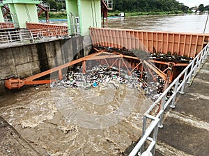 Aerial view of turbid brown forest water released by concrete dam drainage channels as water overflows in the rainy season with