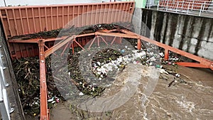 Aerial view of turbid brown forest water released by concrete dam drainage channels as water overflows in the rainy season with dr