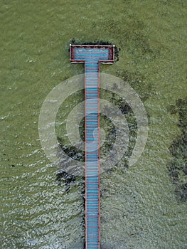 Aerial view of turquoise water with wooden jetty on a lake