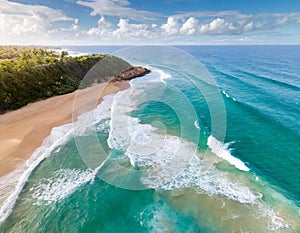 Aerial view of turquoise waves crashing on sunny sandy beach