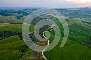 Aerial view of Tuscany rural landscape, road on rolling landscape at sunset, Agriturismo Baccoleno, Asciano, Italy