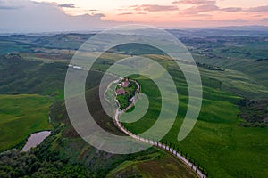 Aerial view of Tuscany rural landscape, road on rolling landscape at sunset, Agriturismo Baccoleno, Asciano, Italy