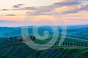 Aerial view of Tuscany rural landscape, road on rolling landscape at sunset, Agriturismo Baccoleno, Asciano, Italy