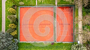 Aerial View of Twin Red Clay Tennis Courts Surrounded by Greenery