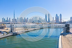 Aerial view of twisted Bridge. Structure of architecture with lake or river, Dubai Downtown skyline, United Arab Emirates or UAE.