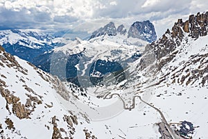 Aerial view of twisting road in the mountains of Italy, is serpentine among the snow-covered hills, is famous place