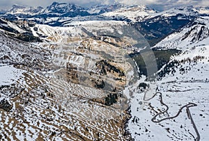 Aerial view of twisting road in the mountains of Italy, is serpentine among the snow-covered hills, is famous place